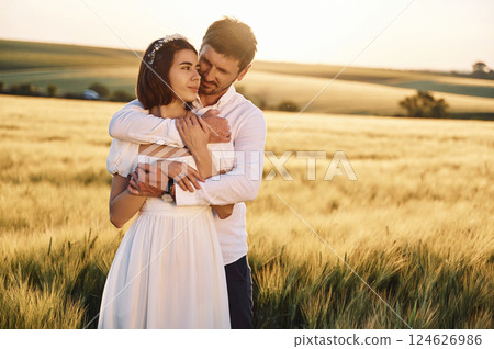 Front view. Embracing each other. Couple just married. Together on the majestic agricultural field at sunny day 124626986