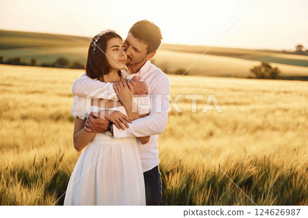 Front view. Embracing each other. Couple just married. Together on the majestic agricultural field at sunny day Front view. Embracing each other. Couple just married. Together on the majestic agricultural field at sunny day 124626987