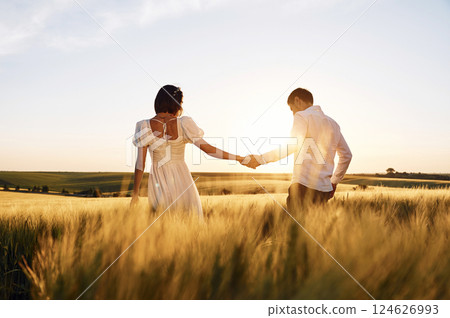 Against beautiful landscape. Couple just married. Together on the majestic agricultural field at sunny day 124626993