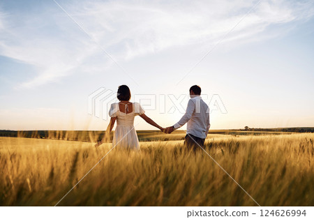 Against beautiful landscape. Couple just married. Together on the majestic agricultural field at sunny day Against beautiful landscape. Couple just married. Together on the majestic agricultural field at sunny day 124626994