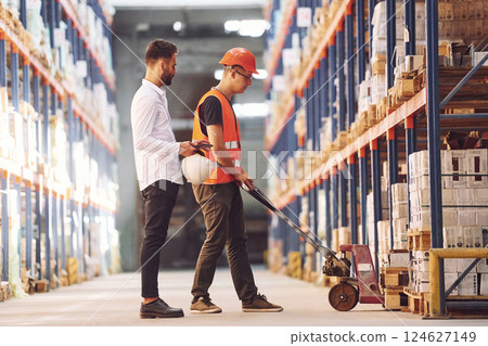 Standing and working together. Two men in storage is in the warehouse 124627149