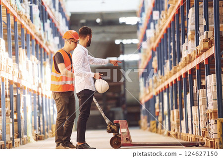 Standing and working together. Two men in storage is in the warehouse 124627150