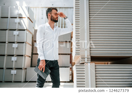 Taking a break. Feeling tired. Storage worker is in the warehouse with bunch of products 124627379