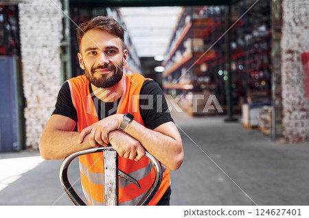 On the trolley platform. Storage worker is in the warehouse with bunch of products 124627401