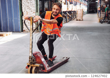 On the trolley platform. Storage worker is in the warehouse with bunch of products 124627402