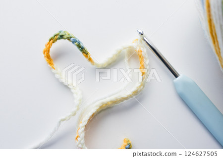 Colorful crochet yarn and hook on white background 124627505