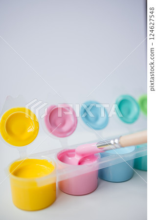 Colorful paint pots with brush in pastel shades Colorful paint pots with brush in pastel shades 124627548