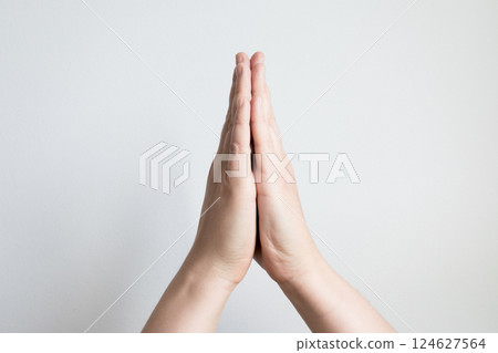 Close up of caucasian adult hands in prayer gesture against white background Close up of caucasian adult hands in prayer gesture against white background 124627564