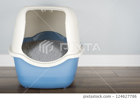 Hooded cat litter box  in the room. 124627786