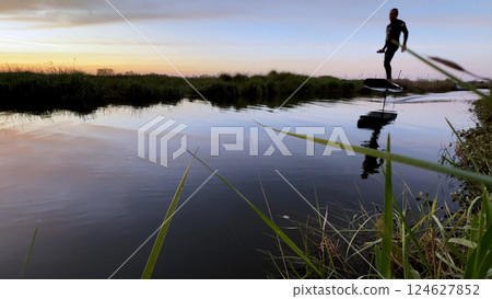 Hydrofoil rider gliding over the water 124627852