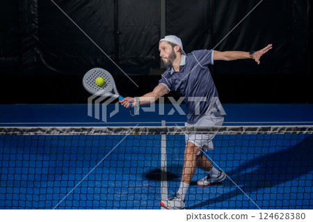 Padel player hitting ball with a racket Padel player hitting ball with a racket 124628380