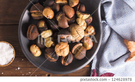 Roasted chestnuts in cast iron pan 124628978
