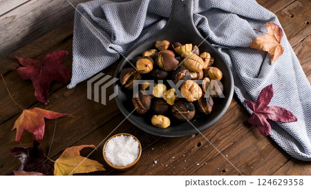 Roasted chestnuts in cast iron pan Roasted chestnuts in cast iron pan 124629358