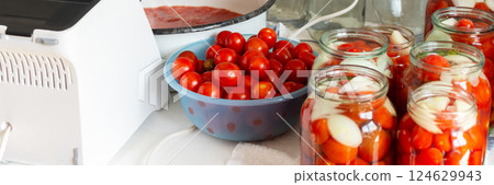 Canning ripe tomatoes and fresh tomato juice, preserving their natural taste for the winter months in airtight jars, kitchen table with prepared jars of tomatoes Canning ripe tomatoes and fresh tomato juice, preserving their natural taste for the winter months in airtight jars, kitchen table with prepared jars of tomatoes 124629943