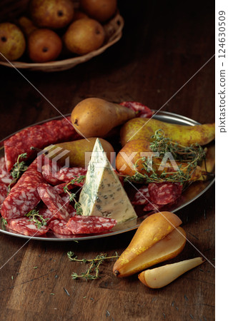 Dry-cured sausages, blue cheese, thyme and pears. Dry-cured sausages, blue cheese, thyme and pears. 124630509