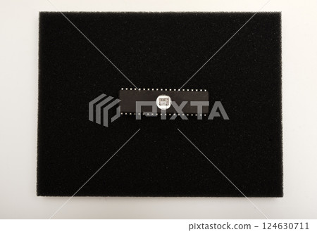 The microcircuit is on black foam. An integrated circuit for radio electronics. 124630711