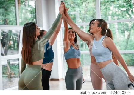 Giving high fives. Group of women practicing fitness in the gym 124630764