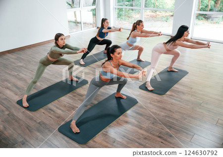 Doing exercises on the mats. Group of women practicing fitness in the gym Doing exercises on the mats. Group of women practicing fitness in the gym 124630792
