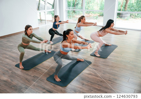 Doing exercises on the mats. Group of women practicing fitness in the gym Doing exercises on the mats. Group of women practicing fitness in the gym 124630793