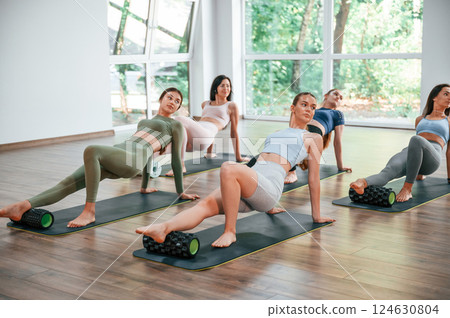 Sitting on the mats. Group of women practicing fitness in the gym Sitting on the mats. Group of women practicing fitness in the gym 124630804