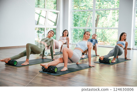 Sitting on the mats. Group of women practicing fitness in the gym Sitting on the mats. Group of women practicing fitness in the gym 124630806