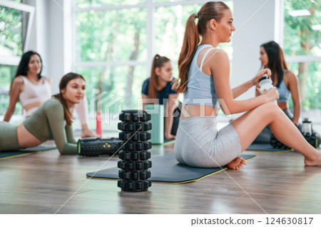 Resting on the mats. Group of women practicing fitness in the gym Resting on the mats. Group of women practicing fitness in the gym 124630817