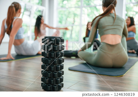 Resting on the mats. Group of women practicing fitness in the gym 124630819