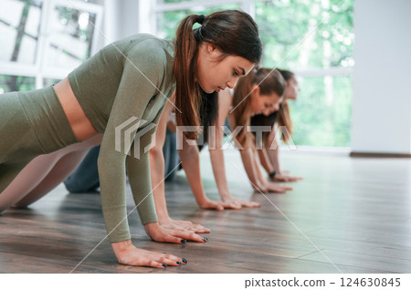 Doing plank. Group of women practicing fitness in the gym Doing plank. Group of women practicing fitness in the gym 124630845