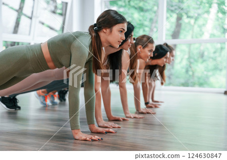 Doing plank. Group of women practicing fitness in the gym Doing plank. Group of women practicing fitness in the gym 124630847