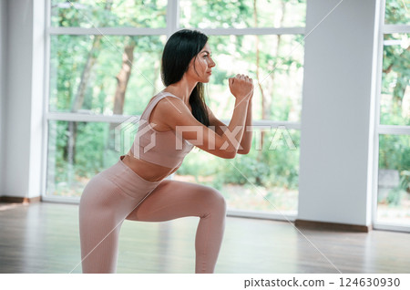 Exercise for legs strength. Woman in sportive clothes is having fitness day in the gym 124630930