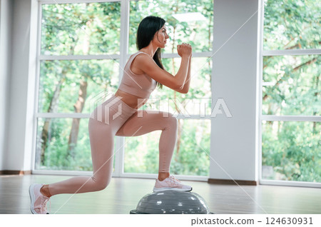 Using special platform. Woman in sportive clothes is having fitness day in the gym 124630931