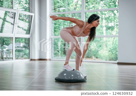 Using special platform. Woman in sportive clothes is having fitness day in the gym 124630932