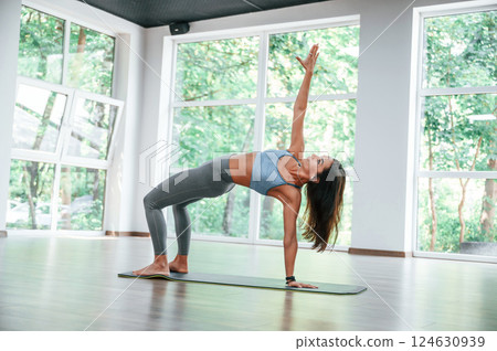 Against big window. Woman in sportive clothes is having fitness day in the gym 124630939