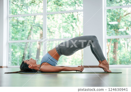 Against big window. Woman in sportive clothes is having fitness day in the gym Against big window. Woman in sportive clothes is having fitness day in the gym 124630941