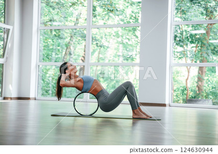 Circle for the spine. Woman in sportive clothes is having fitness day in the gym 124630944