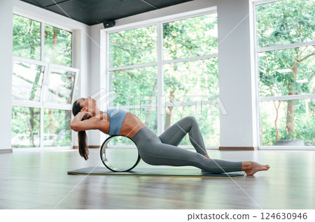 Circle for the spine. Woman in sportive clothes is having fitness day in the gym 124630946