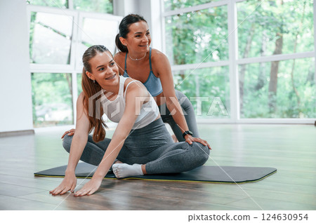 Female trainer helping woman with exercises in the gym Female trainer helping woman with exercises in the gym 124630954