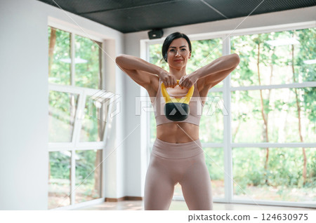 With weight for lifting. Woman in sportive clothes is having fitness day in the gym 124630975