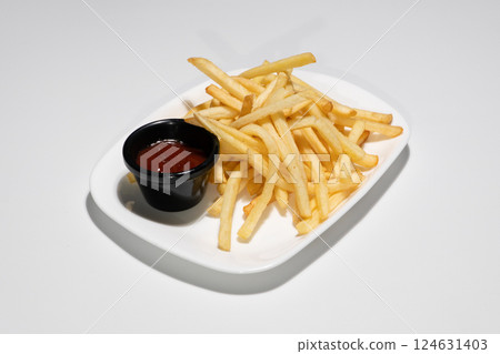Golden Crispy French Fries Served on White Platter with Red Tomato Ketchup Sauce 124631403