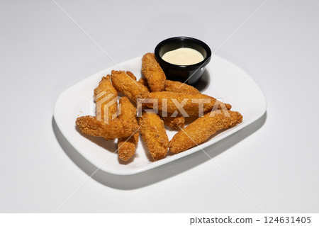 Crispy Breaded Chicken Fingers Served with Creamy Dipping Sauce on a White Plate Crispy Breaded Chicken Fingers Served with Creamy Dipping Sauce on a White Plate 124631405