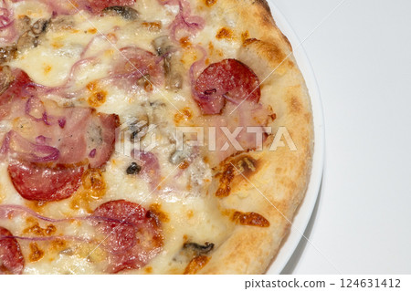Close-Up View of Delicious Homemade Pizza with Melted Cheese, Salami, Mushrooms, and Red Onions on Crispy Golden Crust 124631412