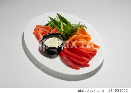 Fresh Vegetable Platter with Sliced Tomatoes, Cucumbers, Carrots, and Bell Peppers Served with Creamy Herb Dip on White Background Fresh Vegetable Platter with Sliced Tomatoes, Cucumbers, Carrots, and Bell Peppers Served with Creamy Herb Dip on White Background 124631422