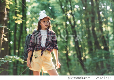Standing and looking at nature. Girl is in the forest at summer day time discovering new places Standing and looking at nature. Girl is in the forest at summer day time discovering new places 124631548