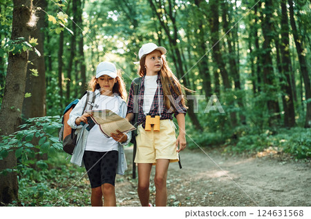Using the map. Two girls is in the forest having a leisure activity, discovering new places Using the map. Two girls is in the forest having a leisure activity, discovering new places 124631568