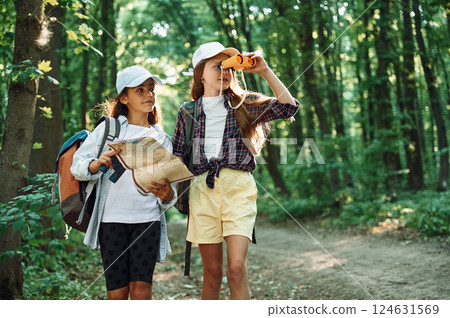 Using the map. Two girls is in the forest having a leisure activity, discovering new places 124631569