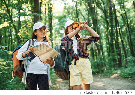 Using the map. Two girls is in the forest having a leisure activity, discovering new places 124631570
