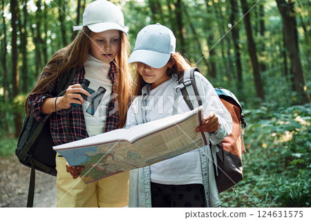 Standing on the footpath. Two girls is in the forest having a leisure activity, discovering new places Standing on the footpath. Two girls is in the forest having a leisure activity, discovering new places 124631575