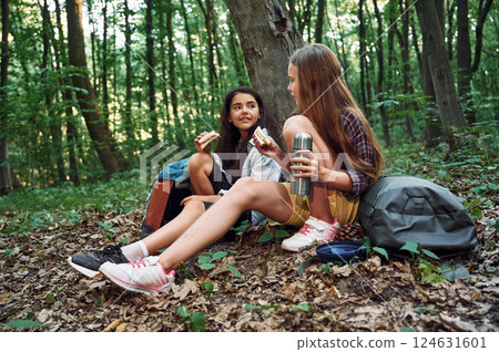 Sitting and eating. Two girls is in the forest having a leisure activity, discovering new places 124631601