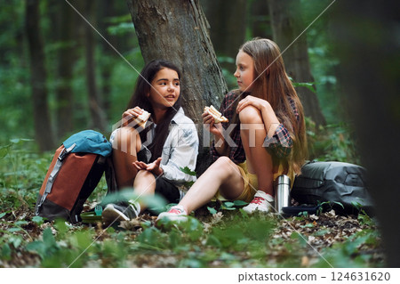 Two girls is in the forest having a leisure activity, discovering new places Two girls is in the forest having a leisure activity, discovering new places 124631620