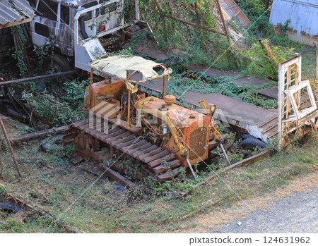 Yellow abandoned tractor was discovered in an abandoned warehouse on the outskirts of town. 124631962